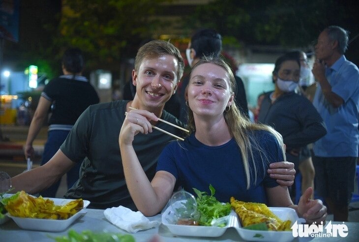 Các du khách nước ngoài thích thú và khen ngợi món ăn Bình Định rất ngon và đậm đà - Ảnh: LÂM THIÊN