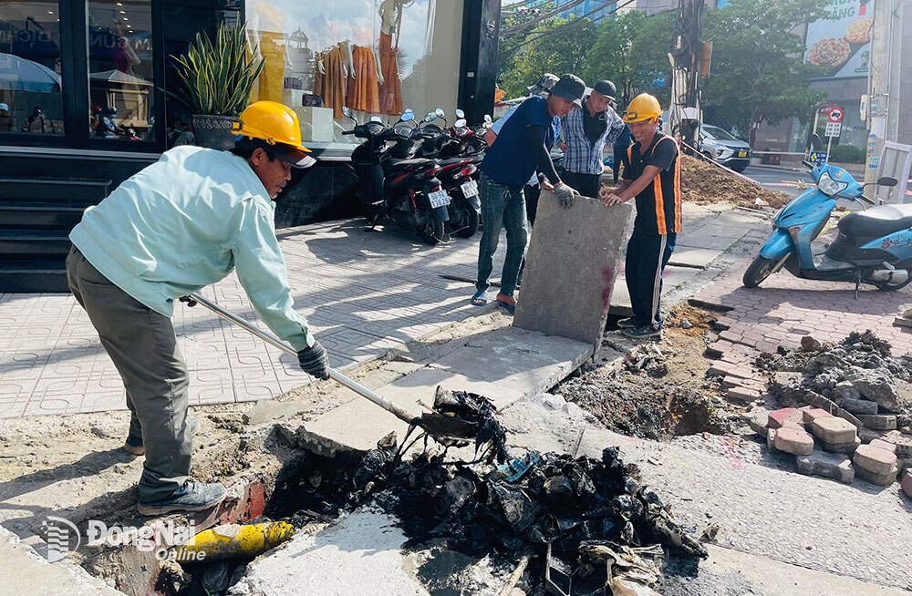 Nhân viên một đơn vị cáp viễn thông đang di dời hệ thống cáp ngầm trên vỉa hè đường Dương Tử Giang (TP.Biên Hòa) để chuẩn bị triển khai công trình mở rộng đường. Ảnh: P.Liễu