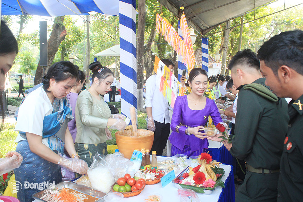 Lưu học sinh Campuchia thưởng thức món ăn Lào tại gian hàng ẩm thực. Ảnh: N.Sơn