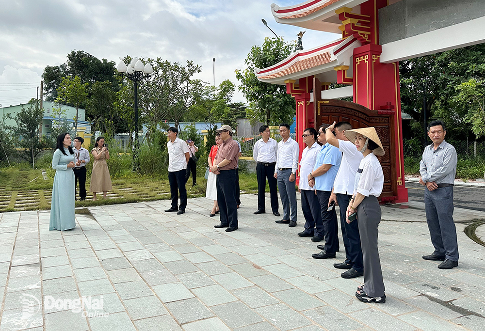 Hướng dẫn viên du lịch giới thiệu đền thờ Nguyễn Hữu Cảnh đến du khách. Ảnh: N.Liên