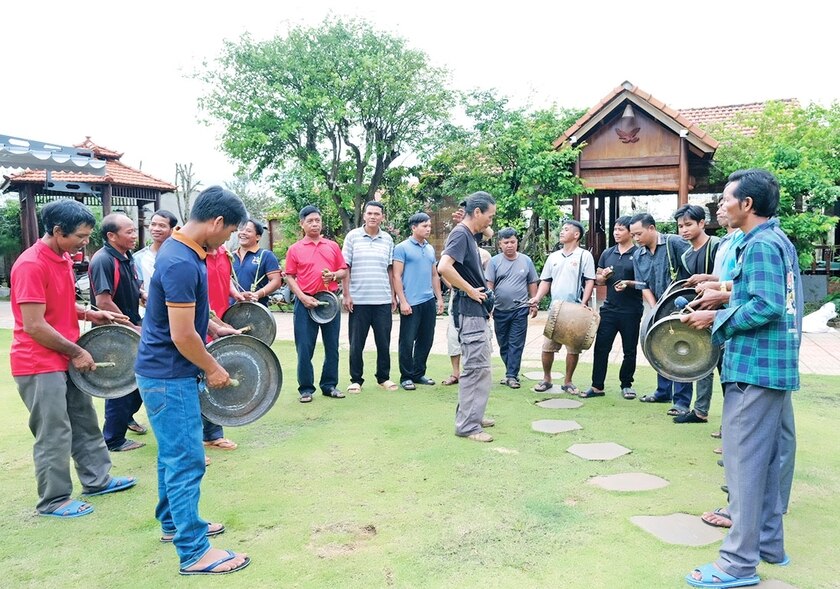 Nhà nghiên cứu Bùi Trọng Hiền lắng nghe âm thanh cồng chiêng sau khi các nghệ nhân Jrai thực hành chỉnh sửa theo phương pháp do ông truyền đạt. Ảnh: H.N