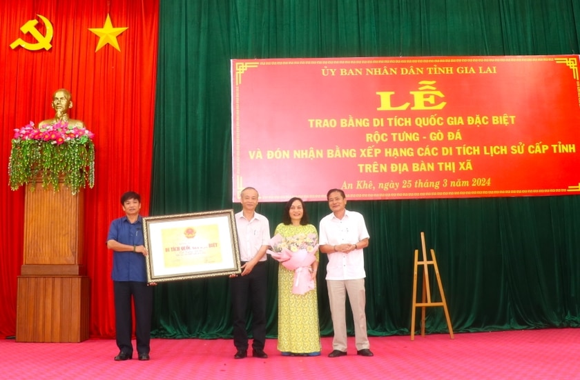 Ông Trần Ngọc Nhung (bìa phải)-Giám đốc Sở Văn hóa-Thể thao và Du lịch tỉnh, Phó Trưởng ban Quản lý di tích quốc gia đặc biệt tỉnh Gia Lai trao lại bằng xếp hạng di tích quốc gia đặc biệt Rộc Tưng-Gò Đá cho thị xã An Khê. Ảnh: Ngọc Minh