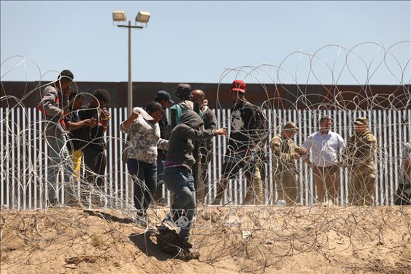 Người di cư vượt qua hàng rào biên giới Mỹ - Mexico ở Texas, Mỹ, ngày 8/5/2023. Ảnh: AFP/TTXVN