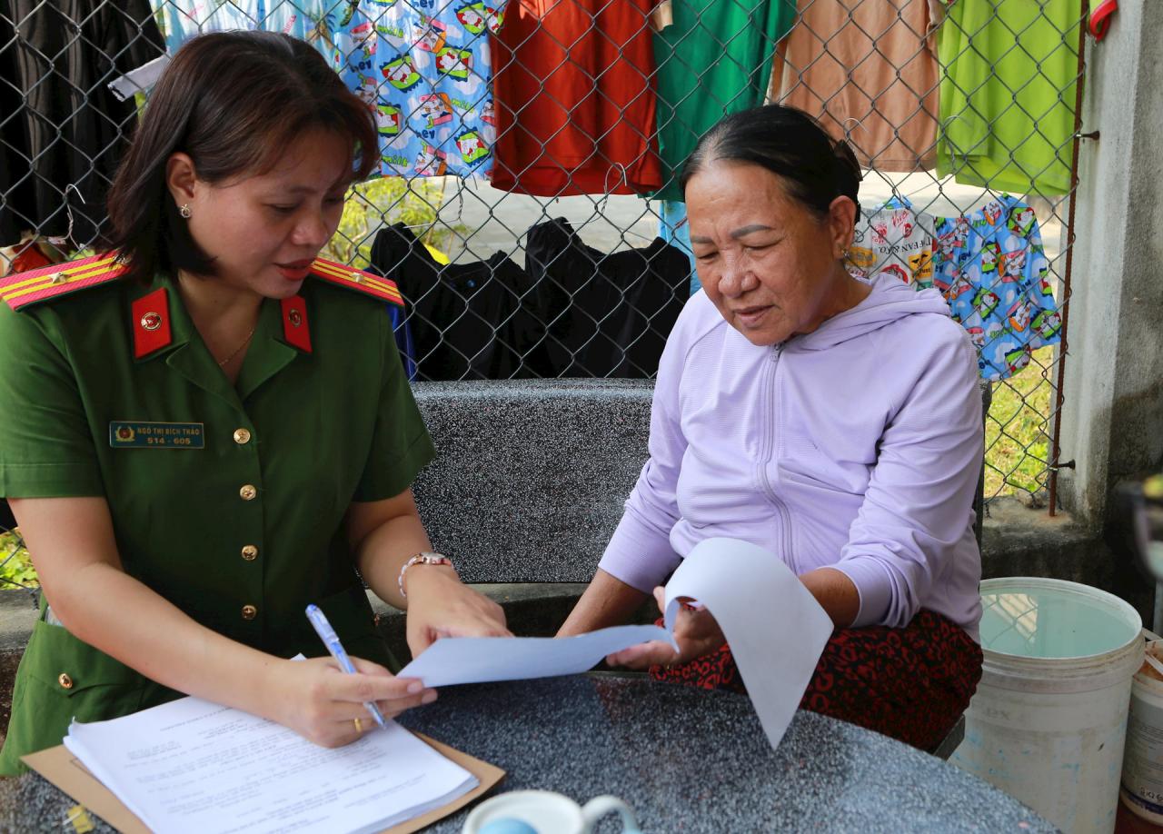 Công an phường Điện Phương (thị xã Điện Bàn) đến nhà tuyên truyền, hướng dẫn đăng ký chi trả an sinh xã hội không dùng tiền mặt. Ảnh: T.C