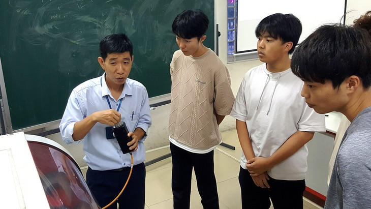 ThS Nguyễn Văn Thông hướng dẫn cho các sinh viên Nhật trong giờ học về máy phay, tiện CNC - Ảnh: TRỌNG NHÂN